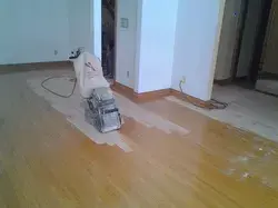 Floor sanding in progress on hardwood planks